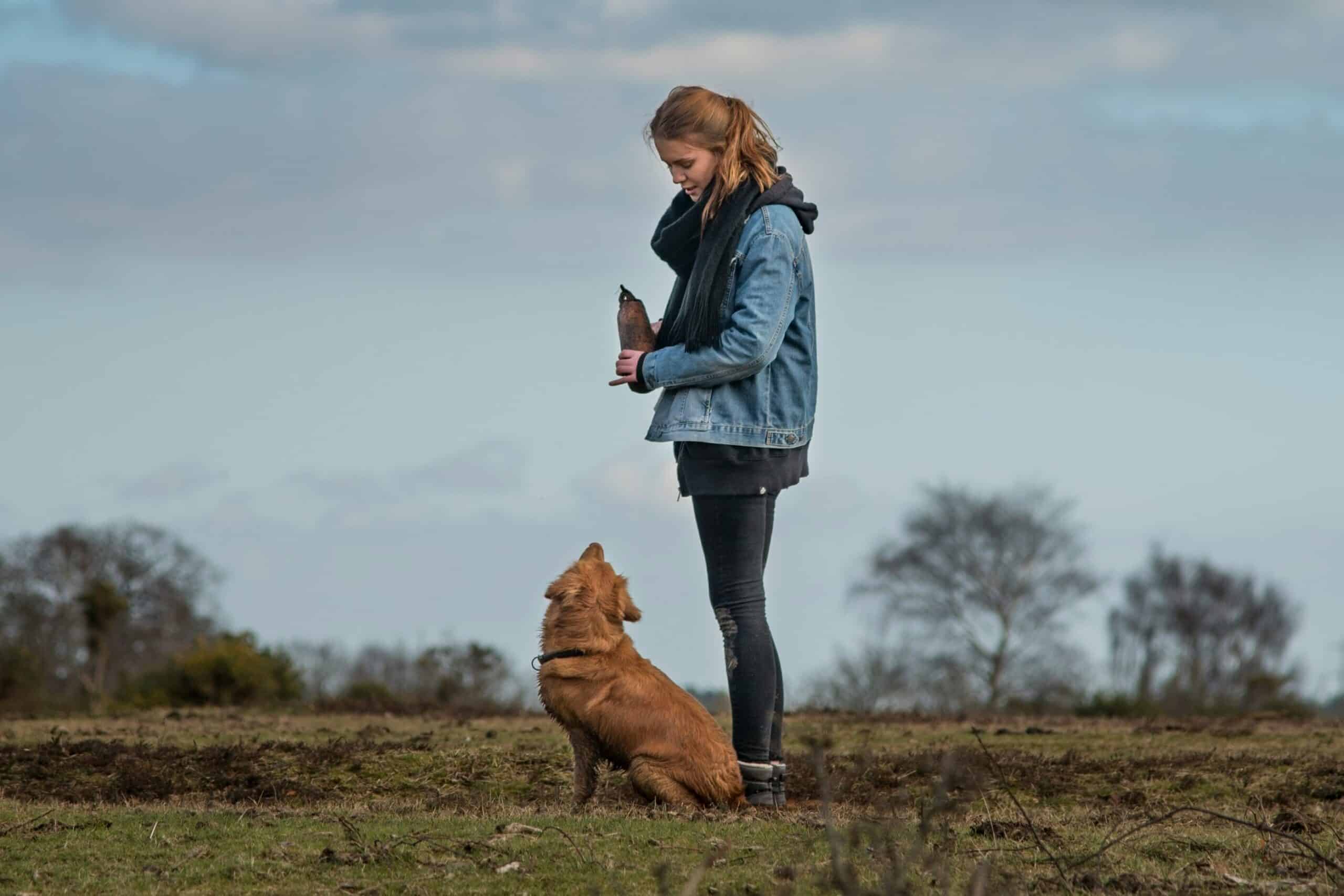 woman and dog standing in a field