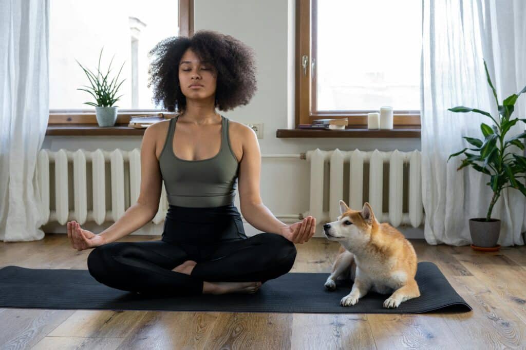 a woman doing yoga with her dog