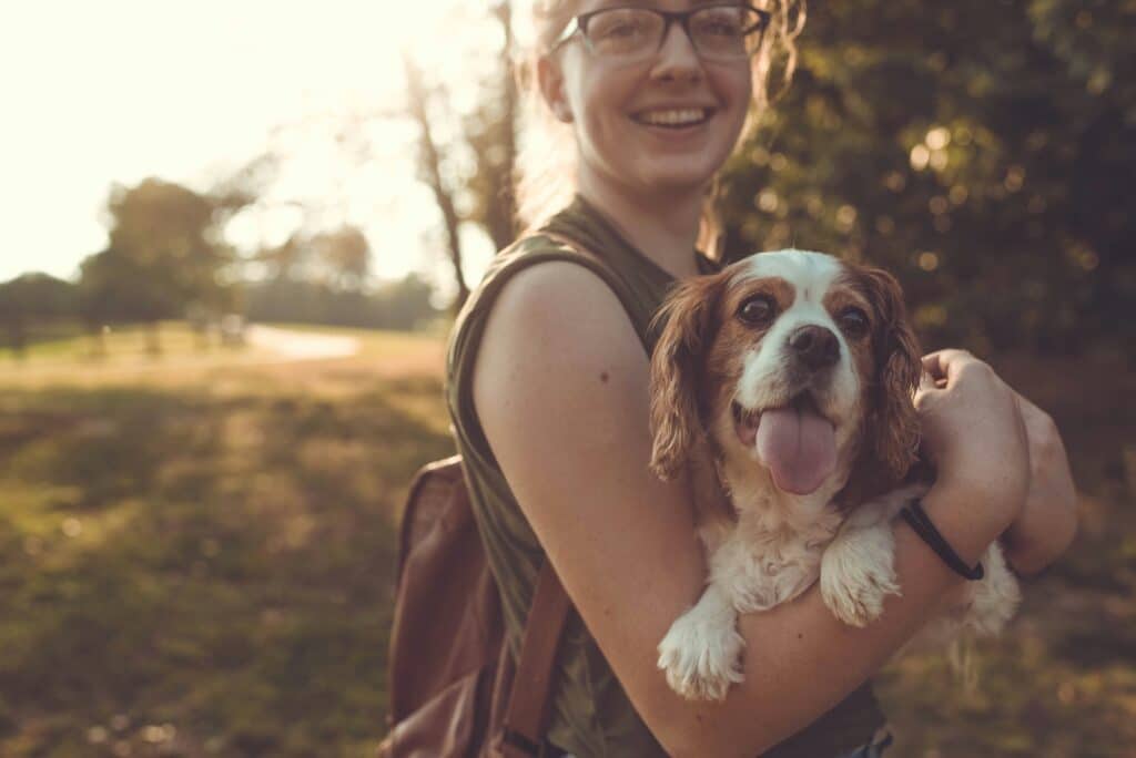 a woman and her dog smiling outside